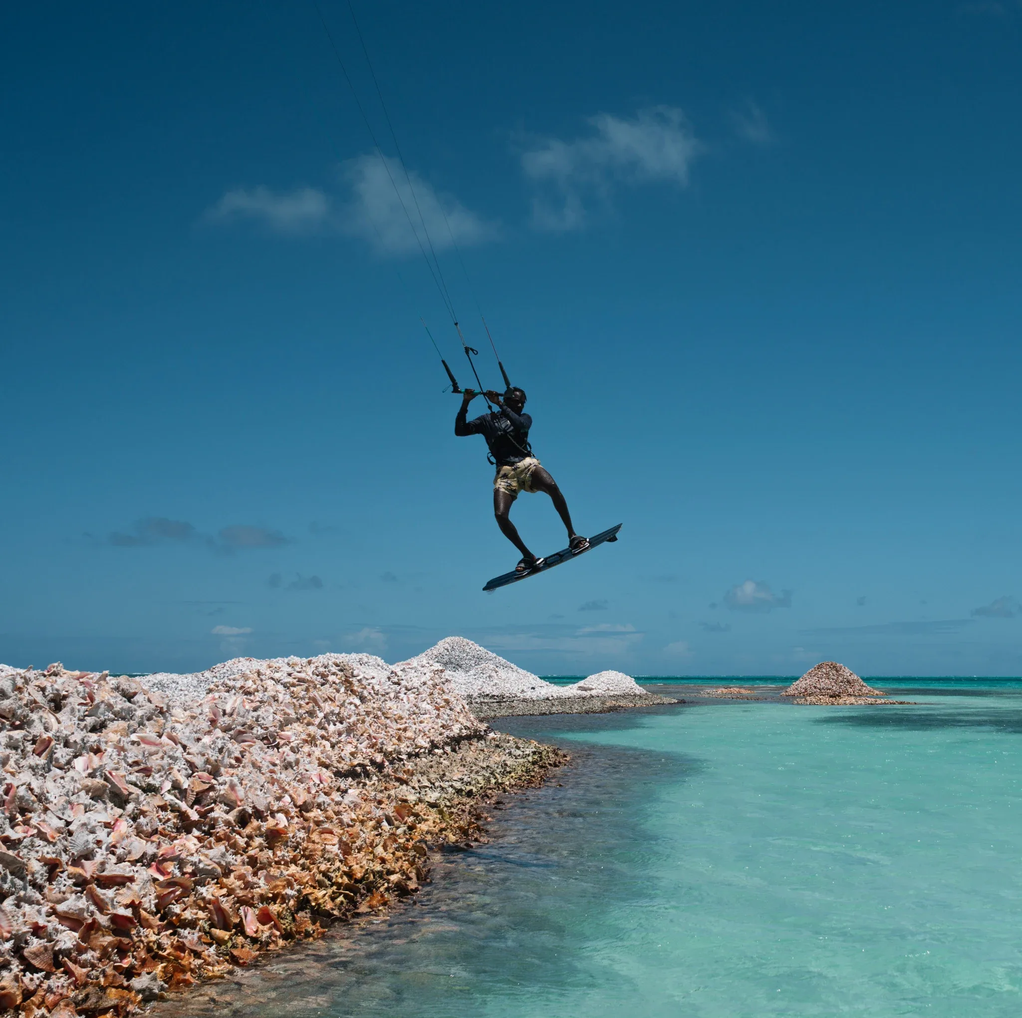 A kiter in the air above the shallows by the conch shell mounds