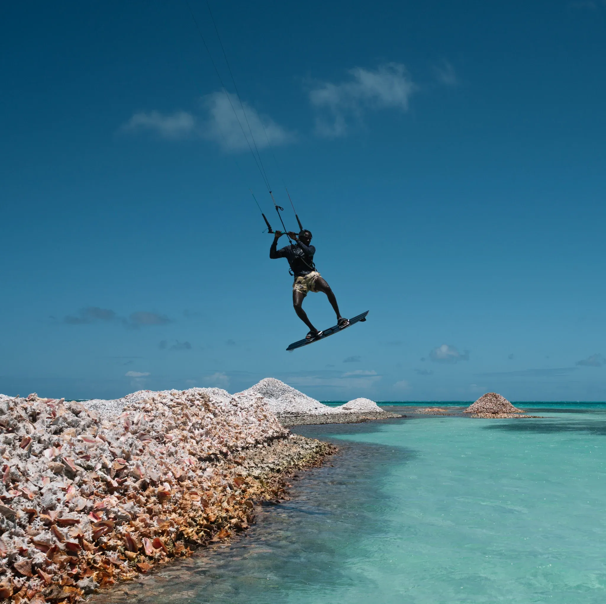 Kitesurfer riding past the conch shell mounds