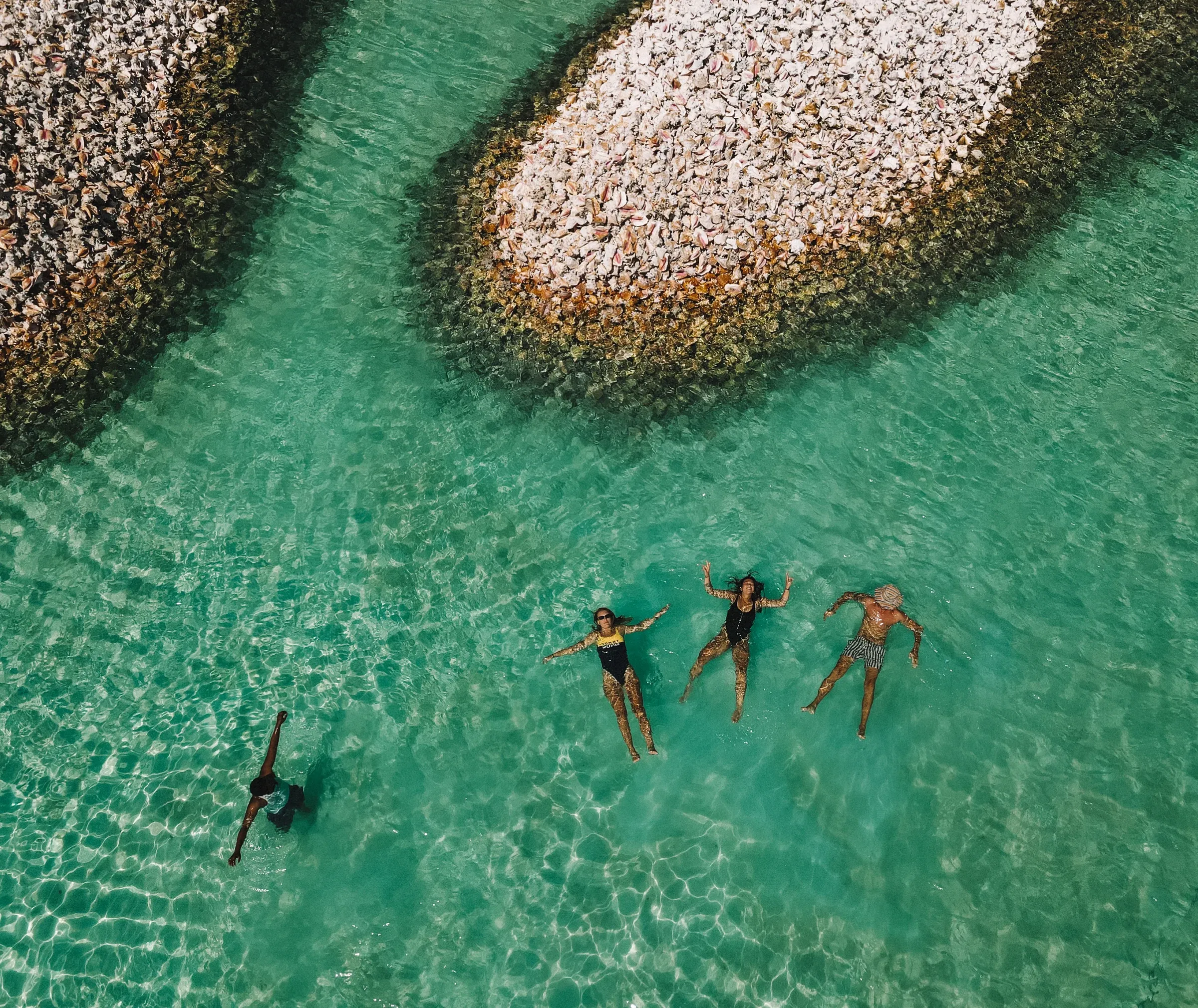 Guests floating in the shallows beside a sandbar